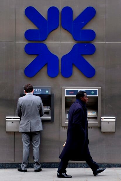 Un cliente del RBS usa un cajero automático en una de las oficinas del banco escocés en Londres.