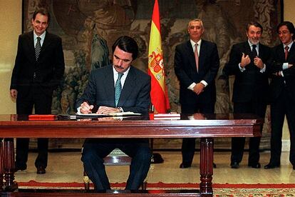 Aznar firma el Pacto Antiterrorista. Detrás, de izquierda a derecha, los entonces secretarios generales del PSOE, José Luis Rodríguez Zapatero, y el PP, Javier Arenas, y los ministros Jaime Mayor y Pío Cabanillas.