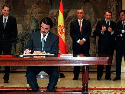 Aznar firma el Pacto Antiterrorista. Detrás, de izquierda a derecha, los entonces secretarios generales del PSOE, José Luis Rodríguez Zapatero, y el PP, Javier Arenas, y los ministros Jaime Mayor y Pío Cabanillas.