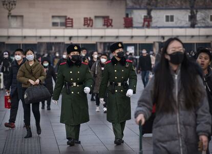 Policías chinos usan máscaras mientras patrullan en la estación de Pekín antes del Año Nuevo chino.