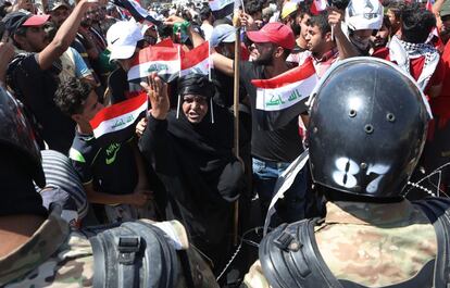 La policía antidisturbios evita que los manifestantes ingresen al edificio del consejo provincial durante una protesta que exige mejores servicios públicos y empleos y contra la corrupción en Basora, al sureste de Bagdad, Irak.