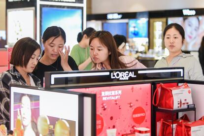 Turistas compran productos de L'Oreal en un duty free de la provincia china de Hainan.