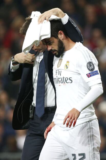 El centrocampista del Real Madrid Francisco Alarcón "Isco" se retira sangrando por la cabeza tras un choque con el defensa marfileño Serge Aurier, del París Saint-Germain.