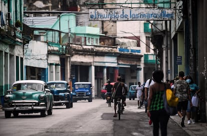 Vehículos antiguos, bicicletas y peatones, en una calle de La Habana en julio de 2021.