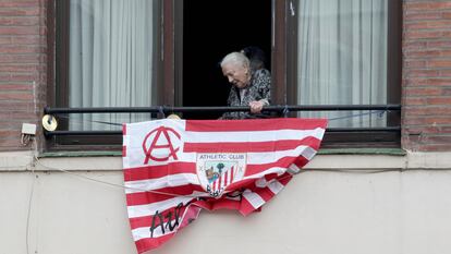 Una mujer junto a una bandera del Athletic antes de las últimas finales de Copa.