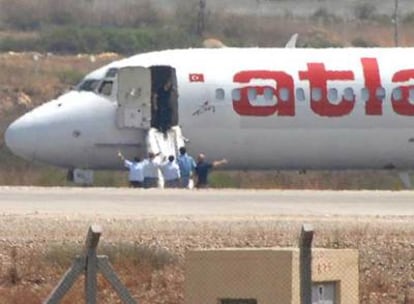 Hombres sin identificar esperan a la entrega de los secuestradores en el aeropuerto de Antalya, en Turquía.