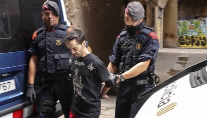 Dos mossos traslladen un dels detinguts.