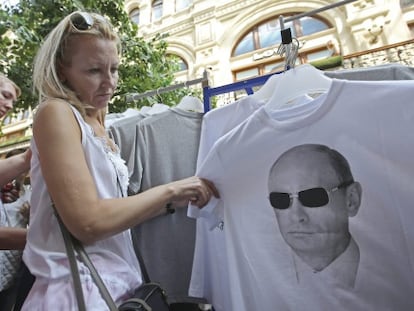 Uma mulher em Moscou observa uma camiseta com a fotografia do presidente russo.