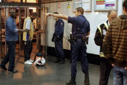Varios policías requieren en el metro de Madrid a personas de raza negra su documentación.