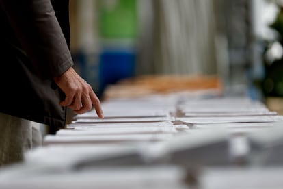 Un hombre observa las papeletas en un colegio electoral de Madrid este domingo durante las elecciones municipales y autonómicas.