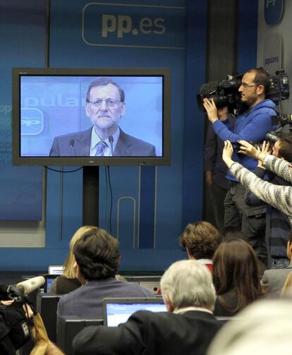 Los periodistas siguen a través de una pantalla de plasma la intervención, el 2 de febrero de 2013, del presidente ante el Comité Ejecutivo del PP, en el que negó haber recibido dinero negro tras la publicación por EL PAÍS de los papeles de Luis Bárcenas,el extesorero del PP imputado en el 'caso Gürtel'.