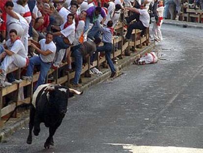 Un toro avanza en solitario tras dejar mortalmente herido a un corredor del encierro.