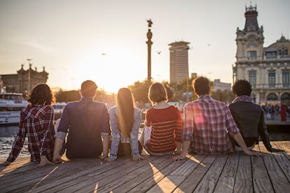 Friends sitting in row on boardwalk