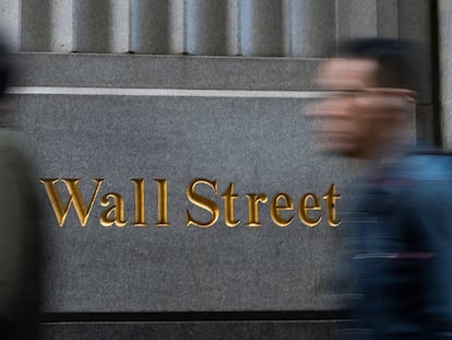 A pedestrian walks down Wall Street on December 29 in New York.