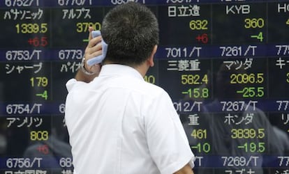 Un inversor observa un panell de cotitzacions a Tòquio (Japó).