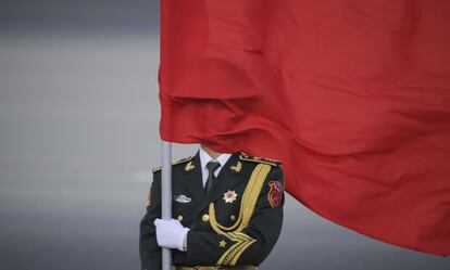 Un guardia de honor chino cubierto por una bandera roja.