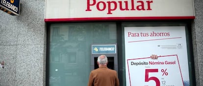 Un hombre sacando efectivo en un cajero de Banco Popular