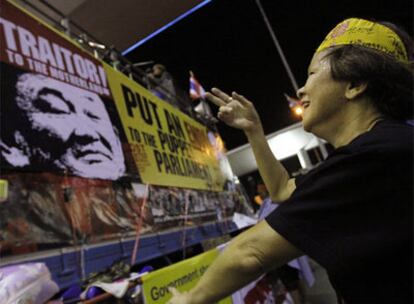 Una manifestante de la oposición tailandesa baila delante de un cartel con la imagen del ex primer ministro Thaksin Shinawtra en el aeropuerto Suvarnabhumi.