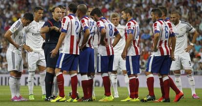 Los jugadores del Madrid y del Atl&eacute;tico discuten con Lahoz en la ida.