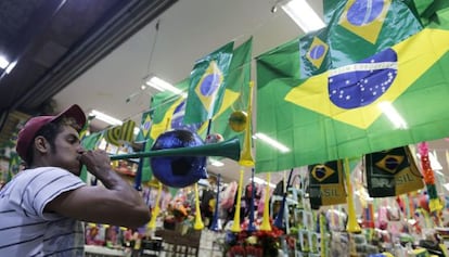 Um homem toca vuvuzela em frente a uma loja de S&atilde;o Paulo. O instrumento est&aacute; proibido nos est&aacute;dios.