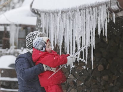 Una ni&ntilde;a juega con unas estalactitas de hielo. 