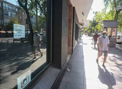 Un hombre camina por delante de un comercio cerrado en la Avenida de Oporto, distrito de Carabanchel (suroeste de Madrid) este miércoles a las 10.30.