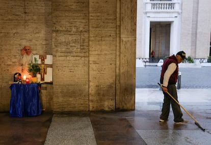 Un hombre limpia el suelo junto a un altar improvisado en recuerdo al Papa, cerca plaza de San Pedro en el Vaticano, el martes.