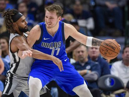 Doncic intenta zafarse de Mills en el Dallas-San Antonio.