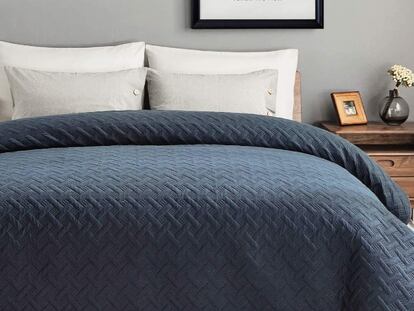 Con un diseño geométrico en relieve, esta colcha de verano se presenta en azul marino, blanco, gris y negro.