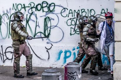 Un grupo de carabineros ataca con bastones al personal voluntario de primeros auxilios.