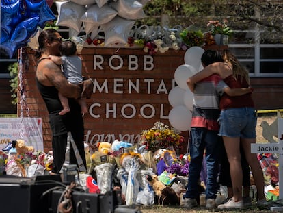 Los visitantes frente a un memorial improvisado frente al letrero de la escuela primaria Robb, en Uvalde, Texas, luego del tiroteo del martes pasado.
