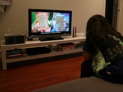 Un niño ve en la televisión en su casa publicidad de alimentos poco saludables.