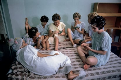 Un grupo de mujeres jugando a las cartas en una cama en Estados Unidos, en 1960. 