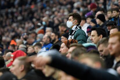 Un aficionado con una mascarilla se levanta durante el duelo del domingo entre el Newcastle y el City.