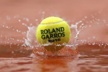 Una pelota de tenis cae sobre un charco de agua del torneo Roland Garros, celebrado en París (Francia).