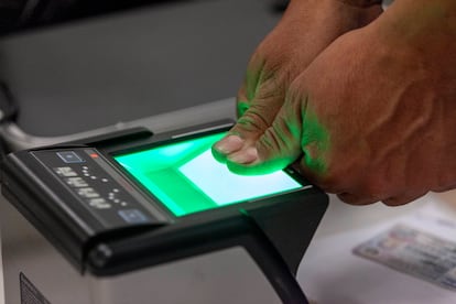 Una persona coloca sus pulgares en un escáner de huellas dactilares.