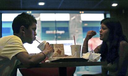 Dos personas, comiendo en un restaurante McDonald's.