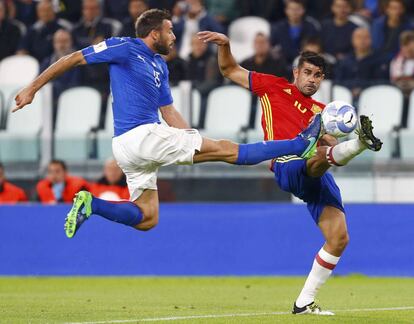 El defensa italiano Andrea Barzagli (i) y Diego Costa de la selección española luchan por la pelota.