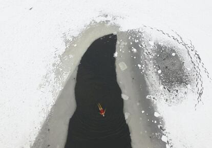 Una mujer nada en un lago parcialmente congelado en un parque de Shenyang, China.