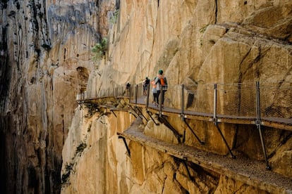 Un grupo atraviesa el desfiladero de El Chorro, en el Caminito del Rey (Málaga).