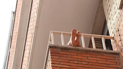 Una persona aprovecha para tomar el sol en su balcón, en Salamanca.