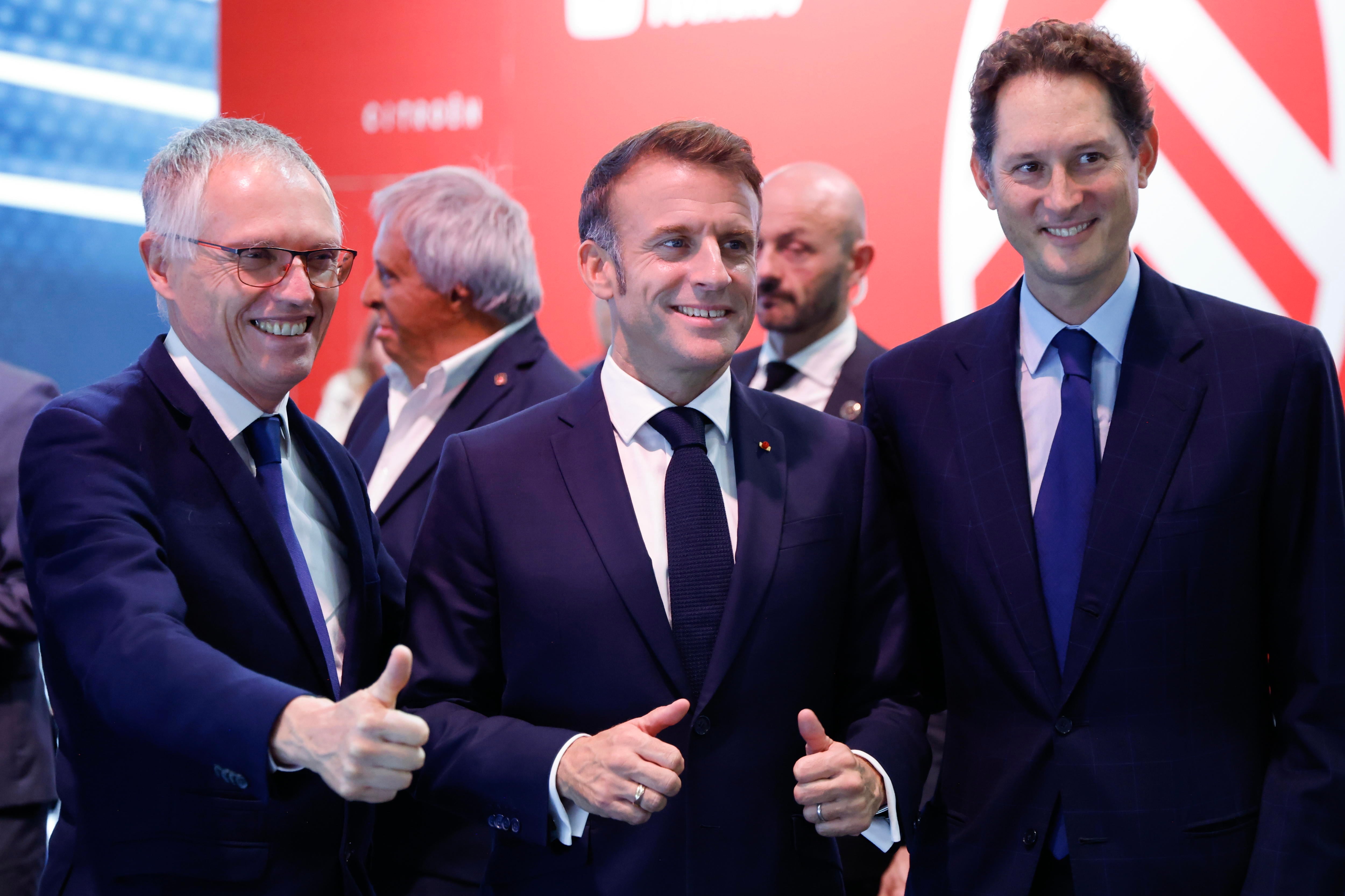 El anterior consejero delegado de Stellantis, Carlos Tavares (i); junto al presidente francés, Emmanuel Macron (c); y el presidente de Stellantis, John Elkann, durante el Salón del Automóvil de París 2024, en octubre.