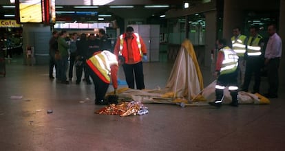 Sanitarios del Samur y vigilantes de la estación de Atocha, en el lugar donde murió Antonio Mena Sanz, el 7 de mayo de 2006, en Atocha.