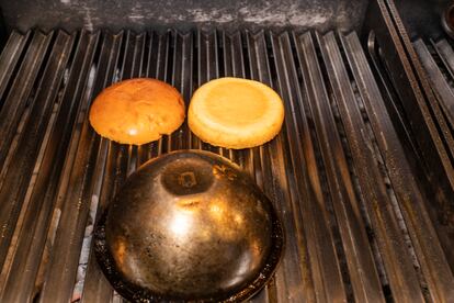 Una vez dada una primera vuelta a la hamburguesa, se le pone encima una loncha de queso cheddar y se tapa con un bol metálico para que se derrita. 