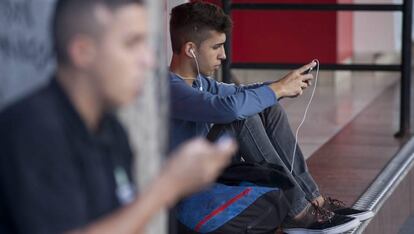 Jóvenes utilizan sus teléfonos móviles.