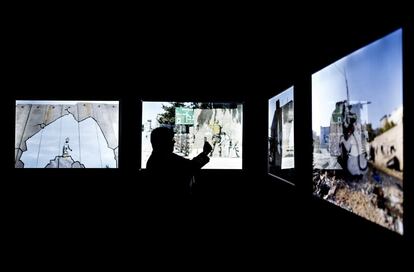 Un visitante mira un vídeo durante la presentación de la Exposición Banksy, en IFEMA. 