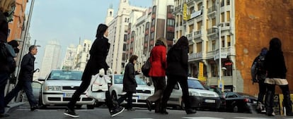 Peatones cruzan la calle Gran Vía de Madrid