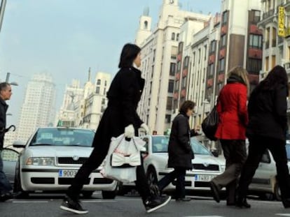 Peatones cruzan la calle Gran Vía de Madrid