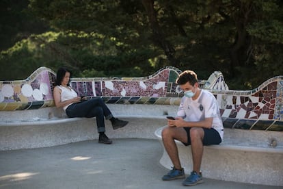 Dos personas descansan en el Park Güell. 