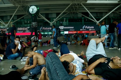 Una familia de migrantes descansa en el suelo de la central camionera.
